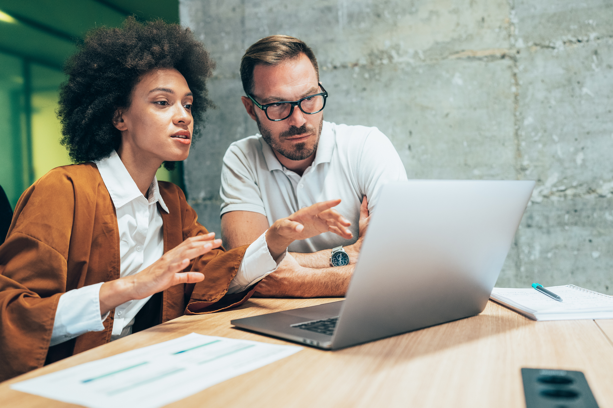 Two business people working together in office monday.com vc concorrentes: qual o melhor